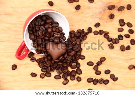 Coffee sweets in the form of heart and a cup with coffee beans spilling on Food and Drink