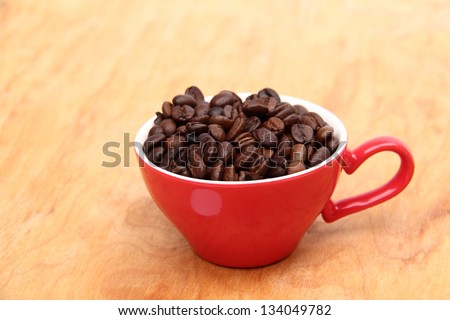 Coffee beans in coffee cup on wooden table on Food and Drink