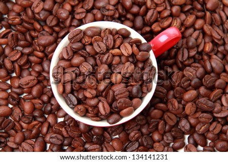 Top view on coffee beans in ceramic red coffee cup on Food and Drink theme