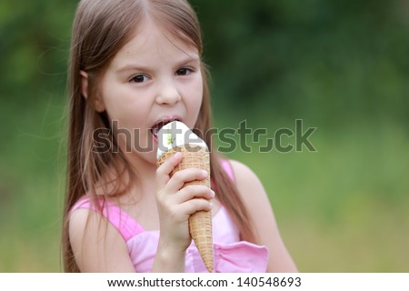 Happy children eating ice-cream outdoors in park