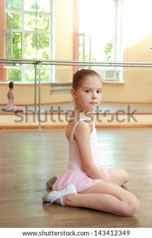 Little gymnast in a tracksuit and a gym shoes in gym class