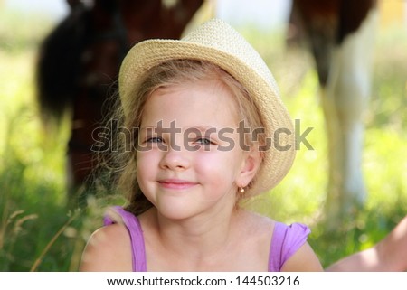 Portrait of a happy little blonde girl with a sweet smile in the countryside