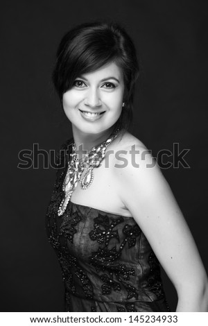 Black and white image of a beautiful young woman in a long dress