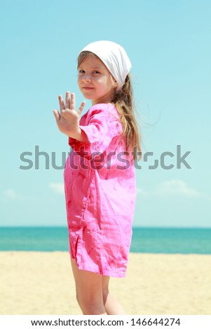 European little girl in bright clothes play and have fun at the sea on a summer theme