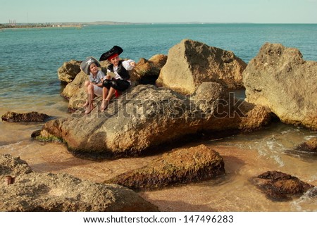 Cute little girl and boy in beautiful costumes, pirate hats and looking for treasure in the seaside/Fancy Dress Pirate on Holiday