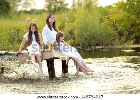 Family holiday mother and two daughters in the nature near the lake