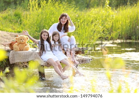 Family holiday mother and two daughters in the nature near the lake in the countryside