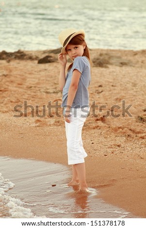 Caucasian girl with long hair and a sweet smile resting on the ocean