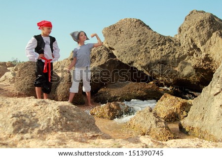 Caucasian boy and girl pirate corsair pirate holding the map in search of treasure on the beach