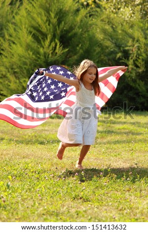 Happy adorable little girl smiling and waving American flag outside/Smiling child celebrating 4th july - Independence Day