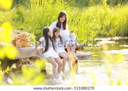Family holiday mother and two daughters in the nature near the lake in the countryside