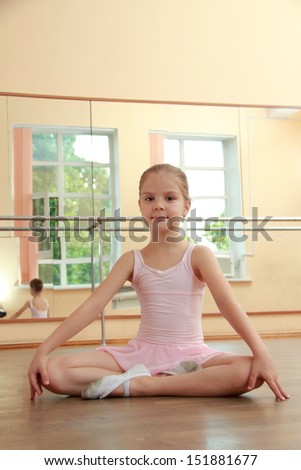 Caucasian ballerina warming up in pointe in the ballet hall on the wooden dance floor