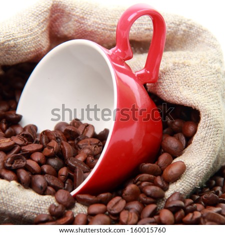 coffee beans in ceramic red coffee cup with heart symbol over burlap beige sack isolated on Valentine Day