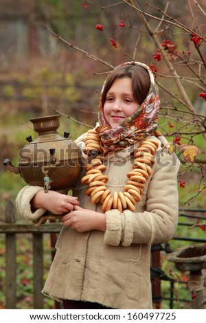 Outdoor image beautiful little girl in russian village traditional kerchief with round cracknel/traditional russian little girl with samovar at autumn outdoor