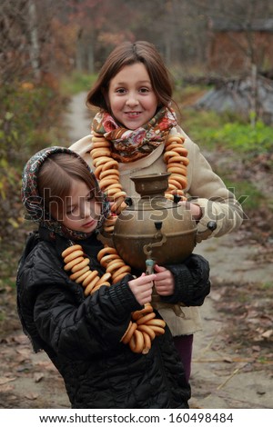 Beautiful little girls in russian village traditional kerchief with round cracknel with russian ornamen over autumn weather/