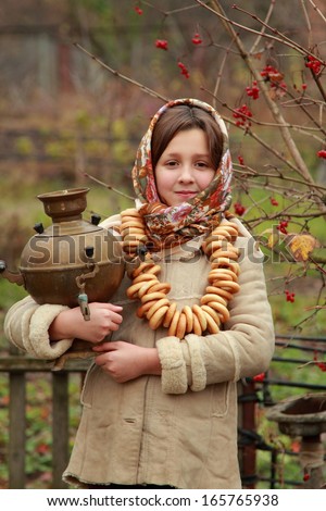 Outdoor image beautiful little girl in russian village traditional kerchief with round cracknel