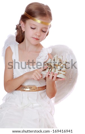 Image of pretty happy smiley little angel with toy tiny house isolated on white on Holiday theme/Little angel holding nice house on isolated background