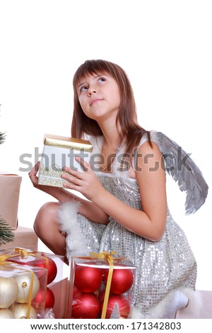 Little happy fairy or angel with magic wings isolated on Holiday theme/Portrait of pretty caucasian little angel wearing silver dress  and holding presents