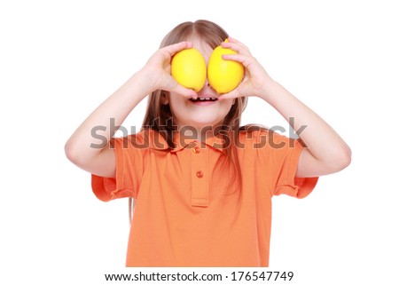 funny beautiful little girl with fresh yellow lemons on Food and Drink theme