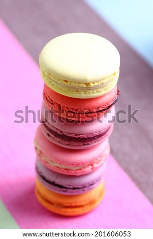 Tasty multicolored macaroon on a light pink background