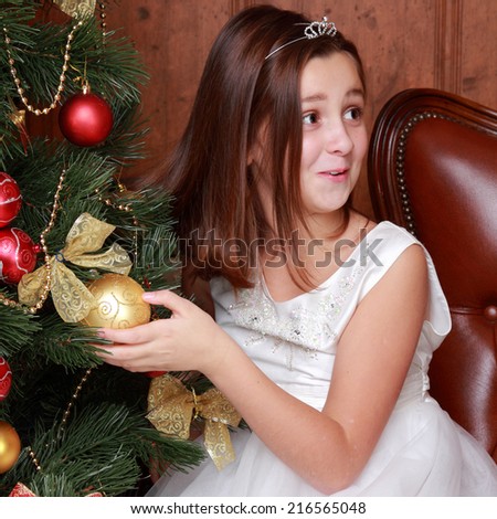 Happy little girl over christmas tree on Holiday theme/Pretty smiley princess in white dress