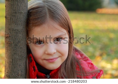 Portrait of female fashion little girl with pretty face at autumn time/Cute girl in autumn park