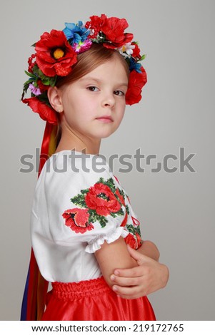 Traditional Ukrainian little girl from east Europe/Emotional little girl in a beautiful Ukrainian costume on a gray background