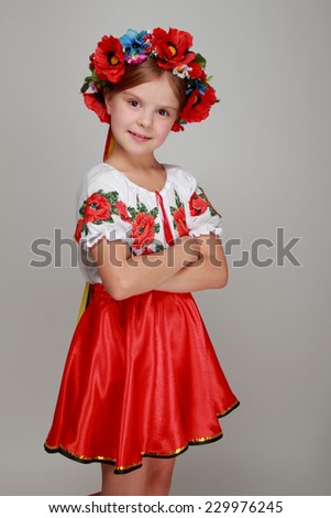 Traditional Ukrainian little girl from east Europe/Emotional little girl in a beautiful Ukrainian costume on a gray background