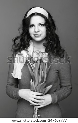 Studio black and white image of young woman with tulips on Holiday