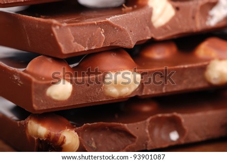 macro shot of nuts and bars of milk chocolates /chocolate with nuts as a background