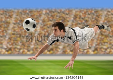 Soccer player heading ball inside stadium