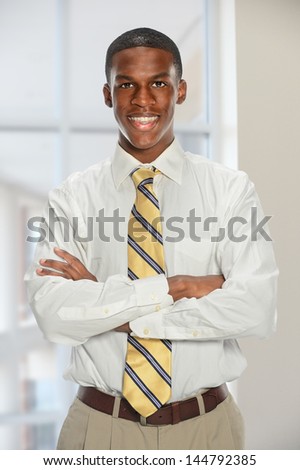 Portrait of African American businessman with arms crossed inside office building