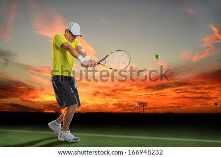 Hispanic tennis player hitting ball during sunset