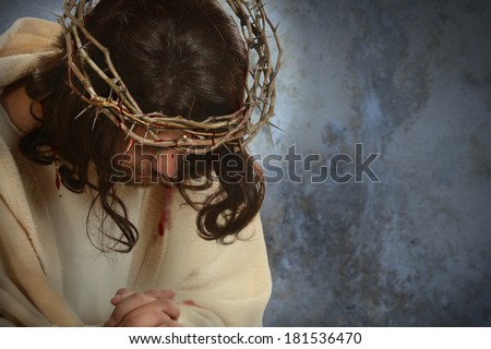 Jesus with crown of thorns with head down over old wall