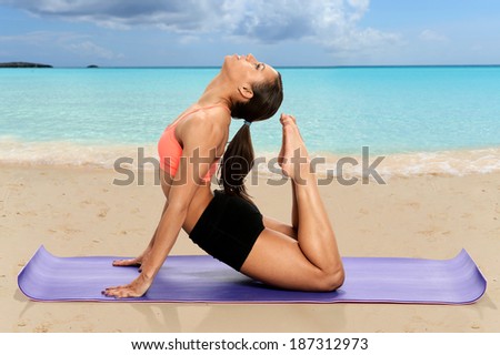 African American woman practicing yoga on the beach