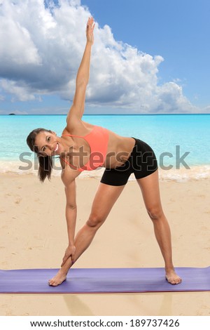 Young African American woman practicing yoga on the beach