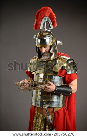 Roman soldier holding crown of thorns over neutral background