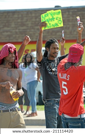 FERGUSON, MO/USA -  AUGUST 15, 2014: Men protest at the site of destroyed Quick Trip after Police Chief Thomas Jackson release of the name of the officer that shot Michael Brown.