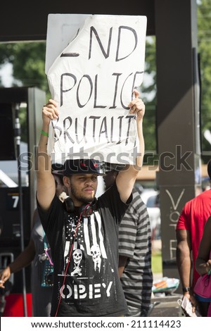 FERGUSON, MO/USA -  AUGUST 15, 2014: Man holds sign at the site of destroyed Quick Trip after Police Chief Thomas Jackson release of the name of the officer that shot Michael Brown.