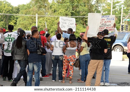 FERGUSON, MO/USA- AUGUST 15, 2014: Crown holds sign at the site of Quick Trip after Police Chief Thomas Jackson release of the name of the officer that shot Michael Brown.