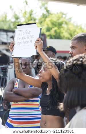 FERGUSON, MO/USA  AUGUST 15, 2014: Woman holds sign at the site of destroyed Quick Trip as reaction to Police Chief Thomas Jackson release of the name of the officer that shot Michael Brown.