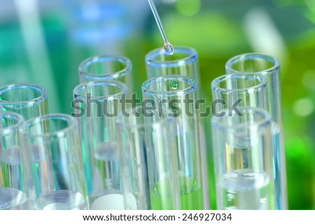 Laboratory glassware with pipette dropping fluid into test tube