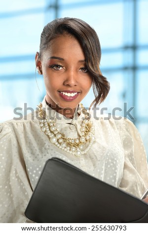 Portrait of young African American businesswoman holding folder