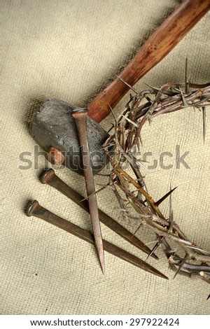 Crucifixion tools including crown of thorns, nails, and hammer over vintage cloth