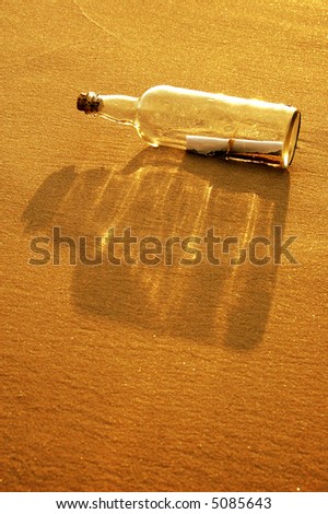 Message in a bottle on a sandy shore at sunset