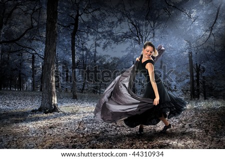 Beautiful woman dancing in the forest during moonlight