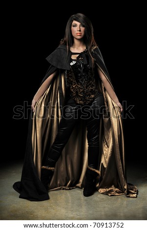 Female vampire standing over dark background with spotlight