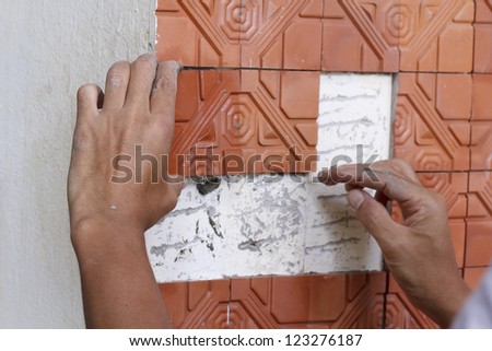 Human hand repairing house wall