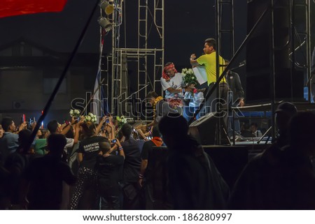 SURAT THANI, THAILAND - MARCH 3, 2014:Thai people give flowers to Dr.Jak Phanchupech before gives a speech anti-government on the protest stage at Chiya on March 3, 2014 in Surat Thani, Thailand.