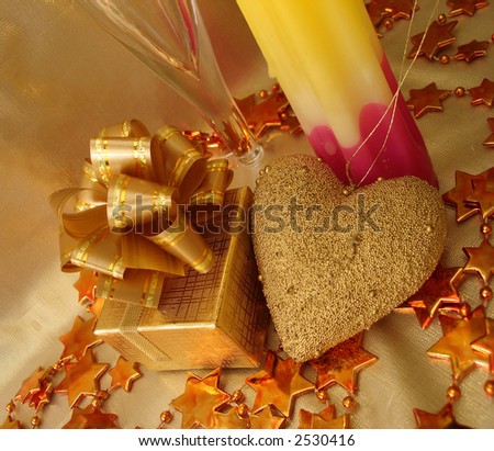 golden heart, gift box and candle on celebratory table